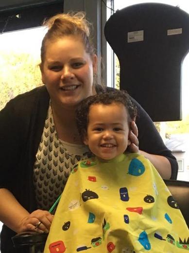 Stylist and smiling young client after a haircut